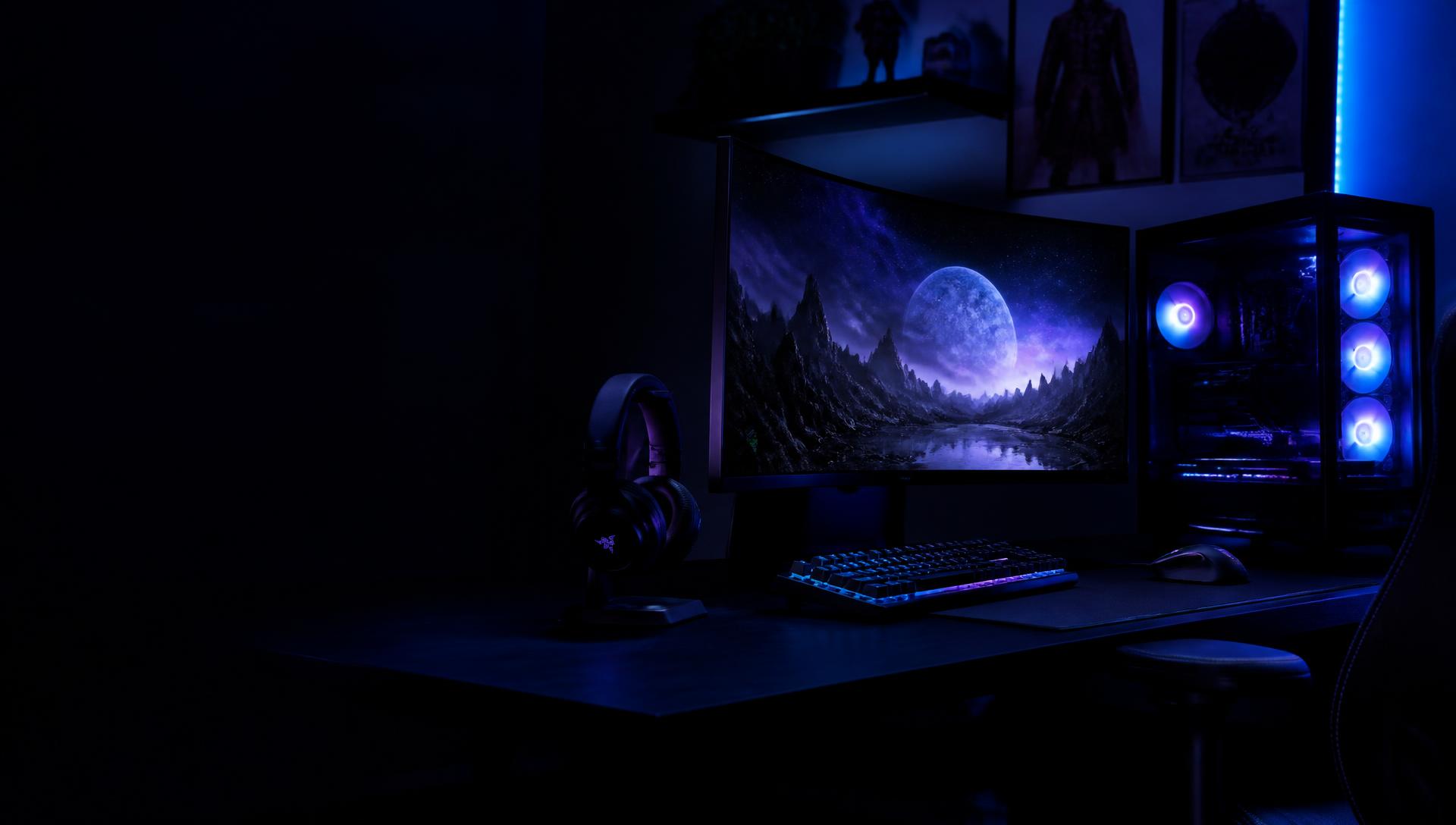 Setup gamer com monitor curvo, teclado RGB e PC com iluminação azul